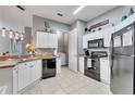 Efficient kitchen with white cabinets and black appliances, next to the laundry room at 505 Terrace Ridge Cir # 505, Davenport, FL 33896