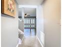Bright foyer featuring tile floors, staircase, and view into the living room with stylish shutters at 6021 Windhover Dr # F11, Orlando, FL 32819