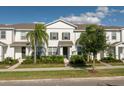 Inviting two-story townhome showcasing lush front yard landscaping with a sidewalk leading to the front door at 6165 Juneberry Way, Winter Garden, FL 34787