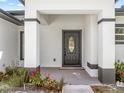 Inviting covered entrance with a charming front door and meticulous landscaping at 675 S Cedar Ave, Orange City, FL 32763