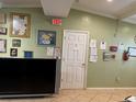 Interior view of an office showing a door, bulletin boards, fire extinguisher and a television set at 8 E Summit St, Apopka, FL 32712