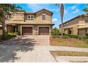 Beautiful exterior view of the townhome featuring a private two-car garage and lovely landscaping at 8925 Azalea Sands Ln # 602, Davenport, FL 33896