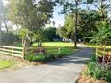 Scenic property view showcasing a long driveway leading to a white house at 29540 Deerwood Farms Rd, Sorrento, FL 32776