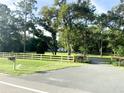 Scenic property view with a long driveway, mature trees, and a charming fence at 29540 Deerwood Farms Rd, Sorrento, FL 32776