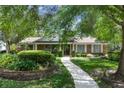Charming brick home with manicured lawn, walkway, and mature landscaping; features a welcoming entryway at 105 Valley Ct, Longwood, FL 32779