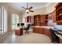 This home office features custom wooden cabinets, a tiled floor, and a large window at 128 Hallstrom Ct, Debary, FL 32713