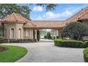 Expansive driveway with lush landscaping leads to a beautiful home near a serene lake at 13025 Water Point Blvd, Windermere, FL 34786