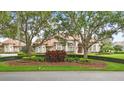 Elegant home exterior boasts lush landscaping, mature trees, and a beautiful tiled roof at 13025 Water Point Blvd, Windermere, FL 34786