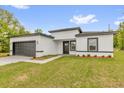 Attractive one-story house showcasing a fresh gray and white color scheme, landscaped yard, and attached garage at 13971 Sw 46Th Ter, Ocala, FL 34473