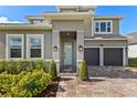 The entryway boasts a light-green door, a brick paver walkway, and well-maintained landscaping at 16018 Volterra Pt, Bella Collina, FL 34756