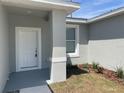 Close up of the front entrance showing a white door and manicured garden bed at 1734 Sail Ct, Kissimmee, FL 34759