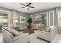 Stylish living room with neutral tones, tile flooring, comfortable seating, and a large screen TV at 2036 Lelani Cir, Davenport, FL 33897