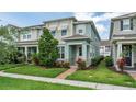 Well-kept two-story townhome featuring an inviting entrance, lush landscaping, and a manicured front lawn at 2214 Centerra Loop, Kissimmee, FL 34741