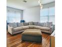 Spacious living room featuring hardwood floors, modern chandelier, and oversized sectional at 2445 Cypress Trace Cir, Orlando, FL 32825