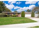 Well-maintained brick home with a two-car garage and a verdant front lawn at 2609 Chinook Trl, Maitland, FL 32751