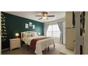 Cozy bedroom with dark accent wall, white furnishings, and a large window at 2618 Lodi Cir # 102, Kissimmee, FL 34746