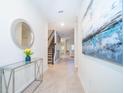 Inviting hallway with sleek tile flooring, modern decor, and staircase access at 2771 Oxymoron Way, Kissimmee, FL 34746