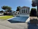Gray single-Gathering home with a front concrete driveway and well-manicured lawn on a sunny day at 3067 Ne 102Nd Avenue Rd, Silver Springs, FL 34488