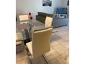 The dining room features a glass table, modern chairs and sleek gray sectional at 3111 Wentworth Ln, Kissimmee, FL 34741
