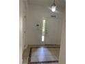 Inviting foyer with neutral tile flooring, adjacent closet and bright front door at 3111 Wentworth Ln, Kissimmee, FL 34741