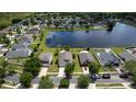 Wide aerial view showing a home, its neighborhood, a pond, and surrounding trees at 4060 Longworth Loop, Kissimmee, FL 34744