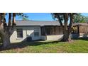 Backyard featuring mature trees offering shade and a screened-in porch for enjoying the outdoors at 4906 Gifford Blvd, Orlando, FL 32821