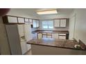 Functional kitchen with white appliances, white cabinetry, and a breakfast bar that offers space for casual dining at 4906 Gifford Blvd, Orlando, FL 32821