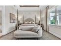 Beautiful main bedroom boasts tray ceilings, a four-poster bed, and a sitting area with lots of light from the windows at 52 Overleaf Ln, Orlando, FL 32839