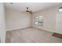 Comfortable living room with neutral carpet, a ceiling fan, and a window for natural light at 543 Auburn Hill Blvd, Auburndale, FL 33823