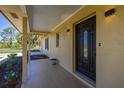 Inviting entryway showcasing a stylish front door, tiled porch and manicured landscaping at 6273 Toronja Dr, Indian Lake Estates, FL 33855