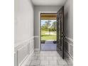 Bright foyer featuring tiled floors, decorative molding, and an open view to the outdoors at 6273 Toronja Dr, Indian Lake Estates, FL 33855
