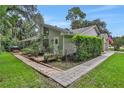 Backyard view showcasing a brick patio area, lush greenery, and the home's architecture at 700 Bear Shadow Ct, Longwood, FL 32779
