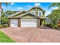 Inviting two-story home featuring a three-car garage and brick paver driveway at 732 Wildmere Village Cv, Longwood, FL 32750