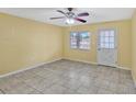 Bright living room featuring tile floors, a ceiling fan, and a door leading to the outside at 1001 Dora Ave, Tavares, FL 32778