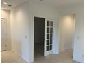 Bright hallway featuring neutral colors with a doorway to a room behind a glass paneled door at 1235 Island Slough Ln, Davenport, FL 33837