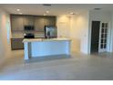 Open concept kitchen with center island and stainless steel appliances, adjacent to a dining area at 1235 Island Slough Ln, Davenport, FL 33837