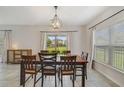Dining room with tile flooring, a wooden table with six chairs, modern light fixture, and a sliding glass door at 1354 Riley Cir, Deland, FL 32724