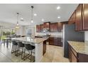 Kitchen with stainless steel appliances, dark wood cabinetry, granite countertops, and a kitchen island with barstool seating at 1354 Riley Cir, Deland, FL 32724