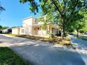 Side view of a two-story home with large porch, nice landscaping and proximity to street at 14521 Tanja King Blvd, Orlando, FL 32828