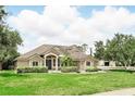 Beautiful home featuring lush green lawn, mature trees, and tasteful landscaping, creating a serene and inviting curb appeal at 158 Hickory Stick Ct, Debary, FL 32713