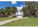 Charming split level home with a well-maintained lawn, mature trees and a welcoming front porch at 201 Glenn St, Leesburg, FL 34748
