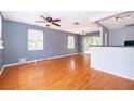 Sunlit living room with hardwood floors, neutral paint and a seamless transition to the dining area at 201 Glenn St, Leesburg, FL 34748