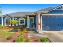 Beautiful one-story home boasting a teal front door, lush landscaping and attached garage at 20321 Majestic St, Orlando, FL 32833