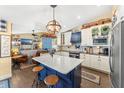 Bright kitchen with white cabinetry, a blue island, an open layout, and stainless steel appliances at 20321 Majestic St, Orlando, FL 32833