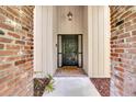 Inviting entryway with decorative front door, brick accents, and charming overhead lantern fixture at 204 Green Lake Cir, Longwood, FL 32779