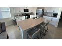 Modern kitchen with stainless steel appliances, a kitchen island, and white cabinetry at 2252 Tay Wes Dr, St Cloud, FL 34771