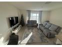 Bright living room with sliding glass doors, comfortable seating, and neutral tones at 2252 Tay Wes Dr, St Cloud, FL 34771