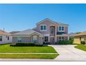 Charming two-story home featuring a well-manicured lawn, lush landscaping, and neutral color palette at 2340 Hinsdale Dr, Kissimmee, FL 34741