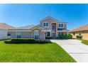 Two-story home showcasing neutral stucco, well-manicured lawn and mature shrubbery at 2340 Hinsdale Dr, Kissimmee, FL 34741