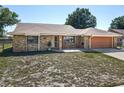 Charming single-story brick home with a tidy lawn and an attached two-car garage at 2470 Pine Tree Circle Dr, Orange City, FL 32763